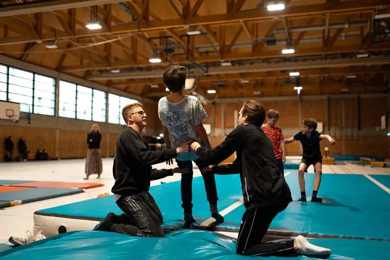 Kinder üben einen Rückwärtssalto auf dem AirTrack bei Movement Family.